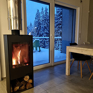 Obývací pokoj apartmánu A8 s hořícím krbem v zimě